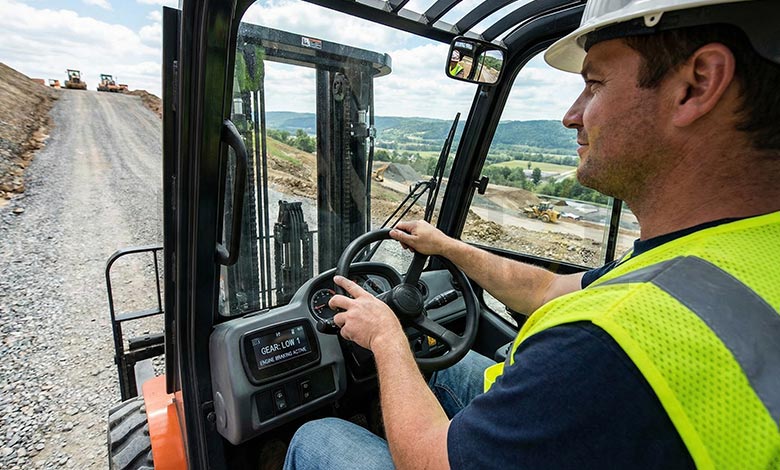 An operator confidently steering down a steep grade with hands on the wheel, not panicking for the brakes.
