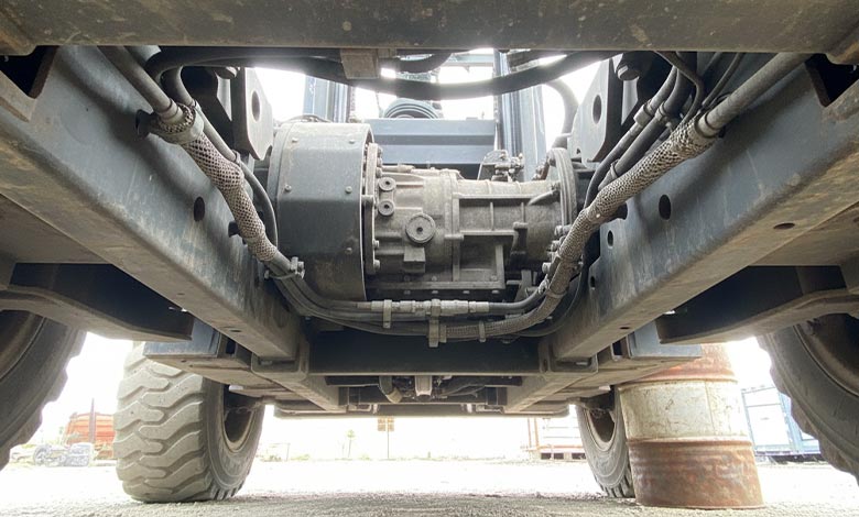 An underside view of a forklift, highlighting protected components like the transmission and hydraulic lines.