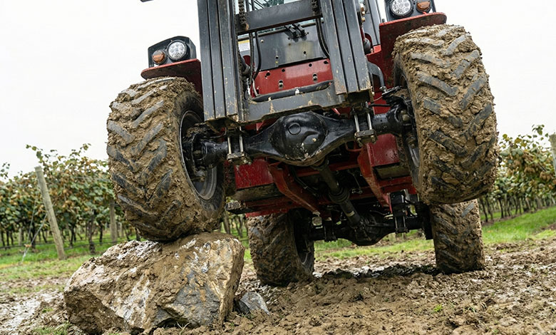 High Ground Clearance Benefit Low angle shot showing the high ground clearance of a BLANC-ELE forklift over a rock.