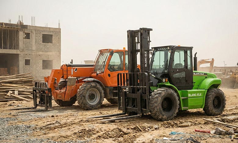 rough terrain forklift and telehandler parked on uneven construction site ground, showing structural difference between mast and telescopic boom