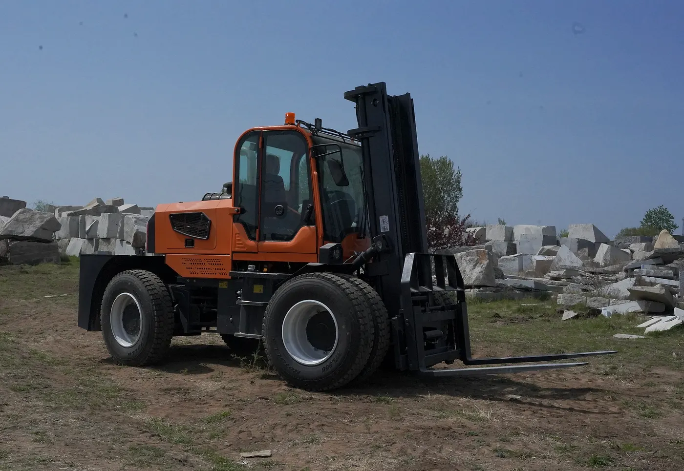 Rough terrain forklift working outdoors where slope, ground condition, and route should be checked before selection