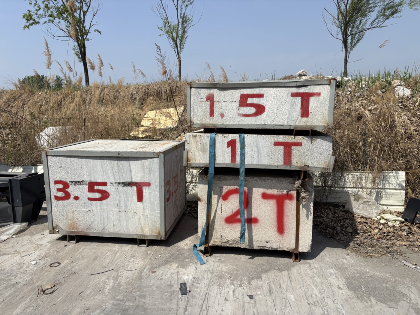 Marked physical weights in a BLANC-ELE yard used to illustrate why visible weight labels are not a complete forklift capacity statement